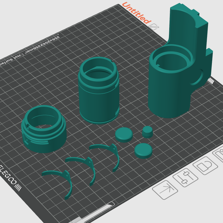 Green 3D printed parts on a gray cutting mat with grid lines